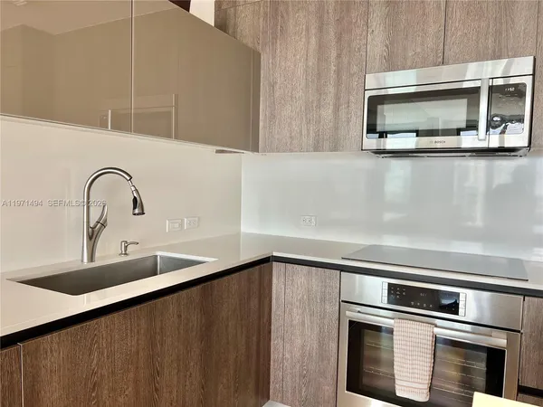 a kitchen with a table chairs sink and cabinets