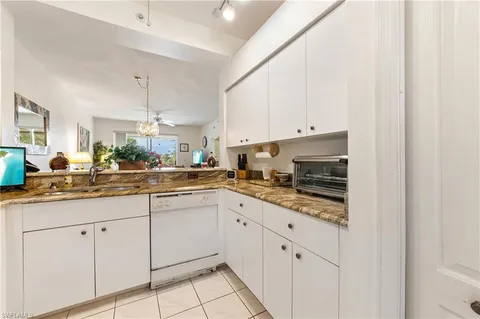 a kitchen with white cabinets sink and white appliances