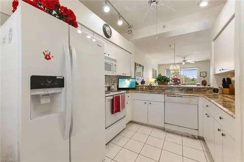 a kitchen with cabinets and chairs
