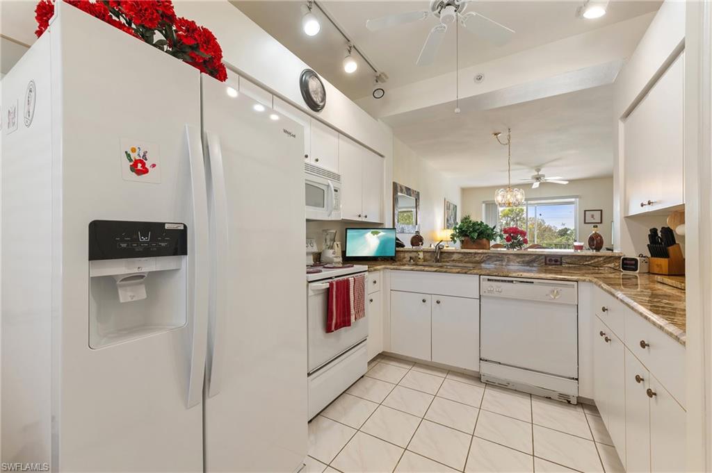 9300 Highland Woods Boulevard, Unit 3206 Bonita Springs, FL 34135 - Photo 4 of 25 a kitchen with cabinets and chairs