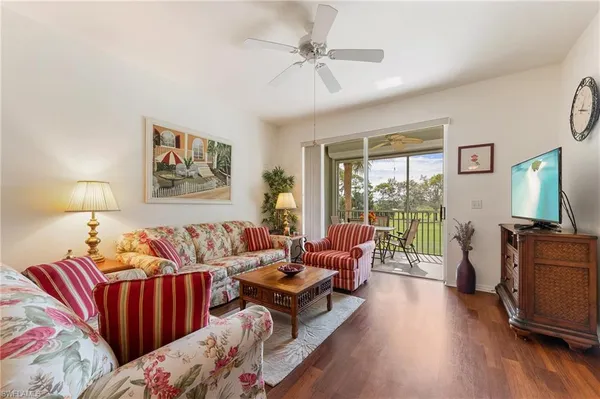 a living room with furniture a flat screen tv and a large window