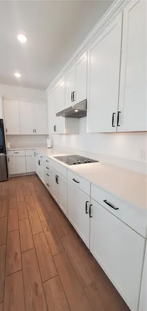 a kitchen with granite countertop white cabinets and white appliances