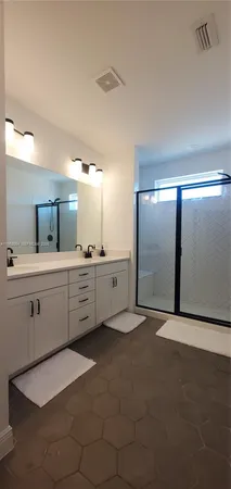 a large bathroom with a double vanity sink and a mirror
