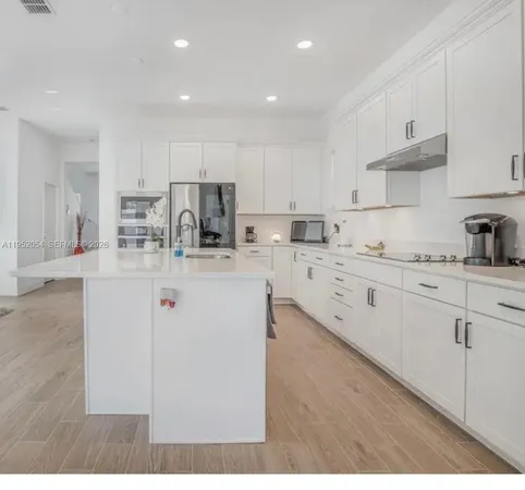 a kitchen with refrigerator and cabinets