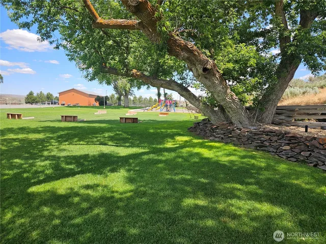 a backyard of a house with lots of green space and fountain in the back