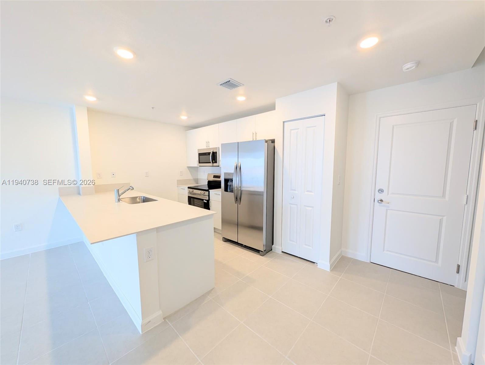 15601 Southwest 280th Street, Unit 4 Homestead, FL 33032 - Photo 4 of 9 a large kitchen with a sink and refrigerator