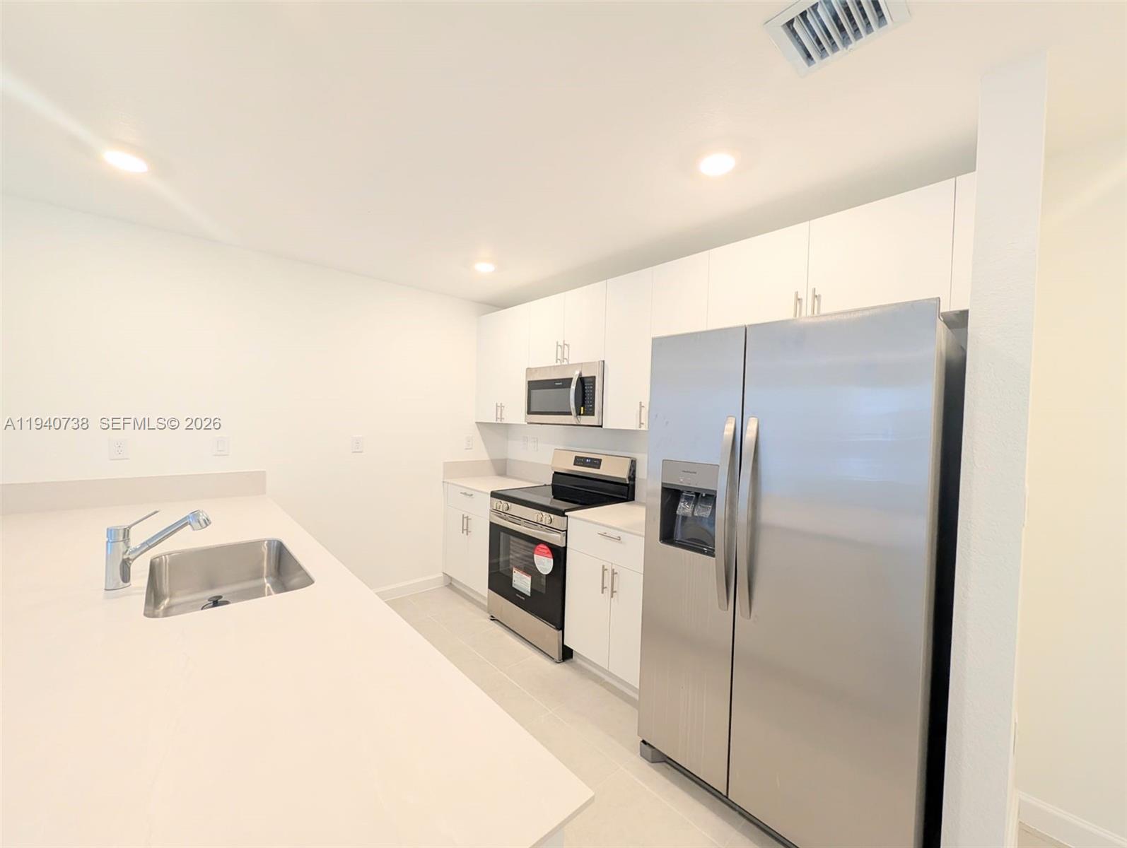 15601 Southwest 280th Street, Unit 4 Homestead, FL 33032 - Photo 5 of 9 a kitchen with stainless steel appliances granite countertop a refrigerator and a sink