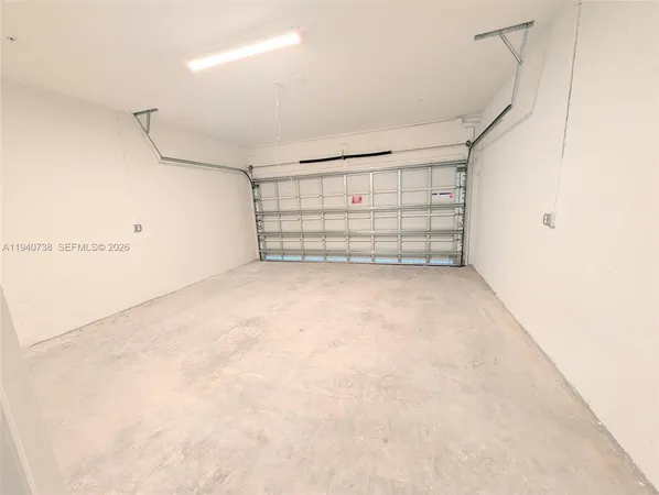 a view of an empty room with closet and racks on the wall