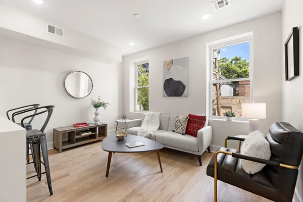 a living room with furniture a chandelier and a window