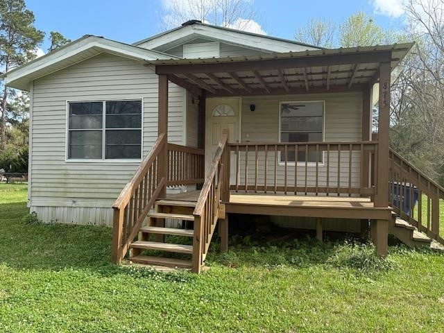 875 Woodrow Street Silsbee, TX 77656 - Photo 2 of 10 a view of a house with a small yard and a wooden deck