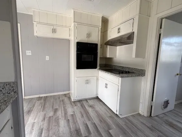 a kitchen with white cabinets and white appliances