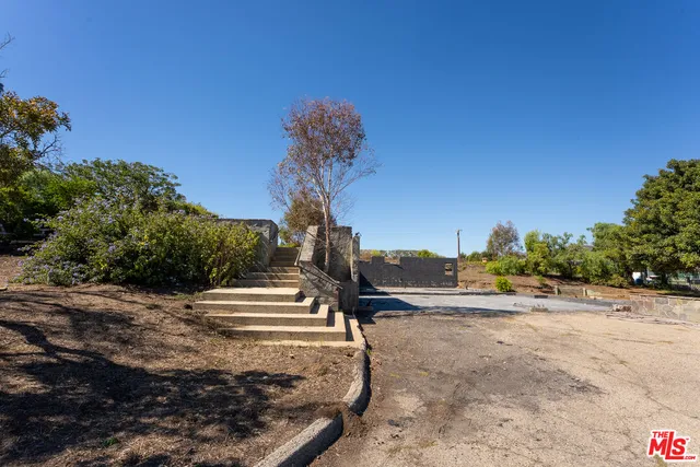 a view of a dry yard with wooden fence