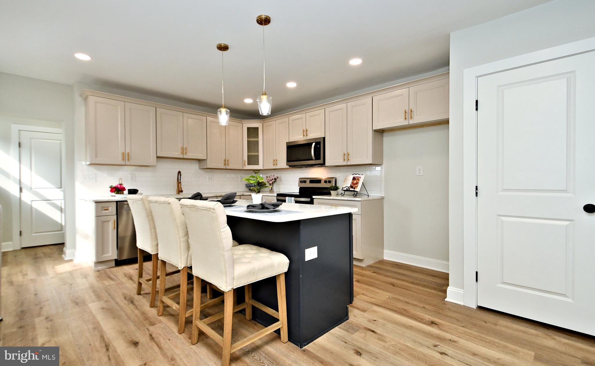 a kitchen with a dining table chairs refrigerator and cabinets