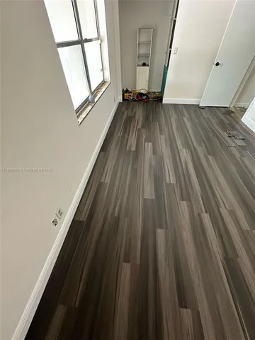 a view of a room with wooden floor and a window