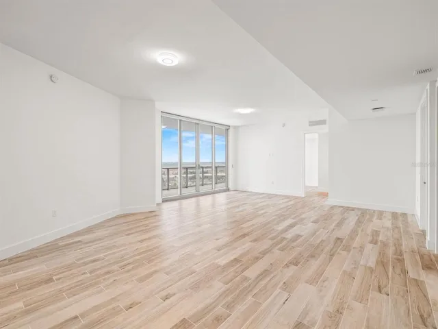 a view of empty room with wooden floor