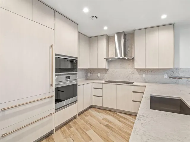a kitchen with granite countertop white cabinets and stainless steel appliances