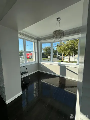 a dining room with wooden floor a chandelier a wooden table and chairs