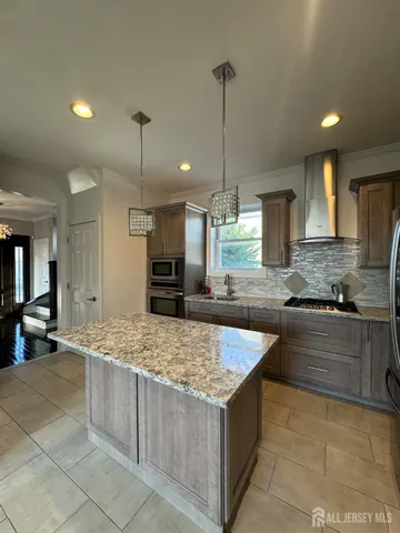 a kitchen with stainless steel appliances kitchen island granite countertop a sink and cabinets
