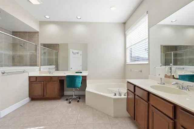 a bathroom with a bathtub shower sink and mirror