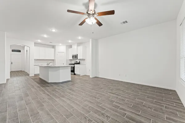 a view of kitchen with granite countertop cabinets and refrigerator