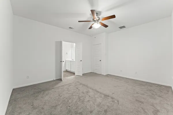 an empty room with a ceiling fan and a window