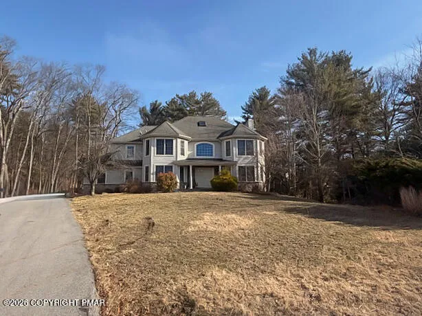 a front view of house with yard and trees around