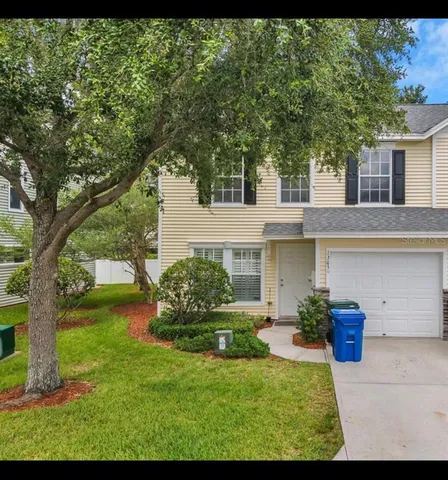 a view of a house with backyard and a tree