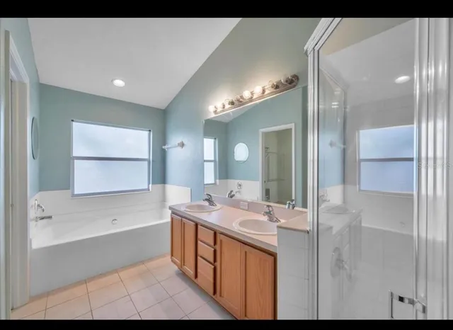a bathroom with a tub sink and mirror