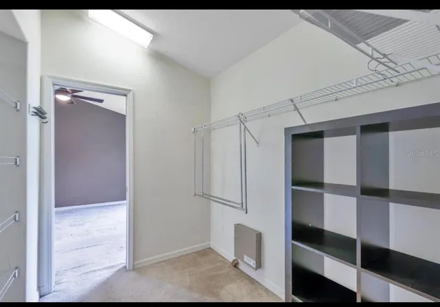 a view of walk in closet with empty racks