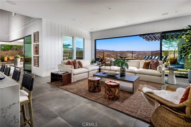a living room with furniture potted plant and large windows