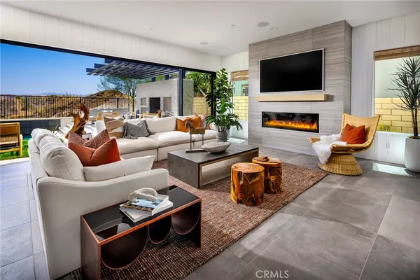 a living room with furniture a flat screen tv and a fireplace