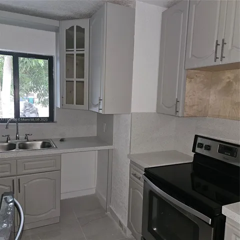 a kitchen with sink cabinets and window
