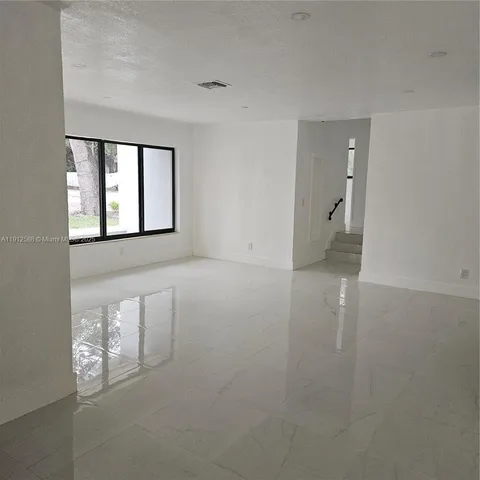 a white house that has a tree in front of it