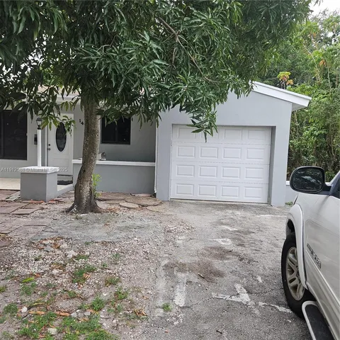 a view of a house with backyard and a tree