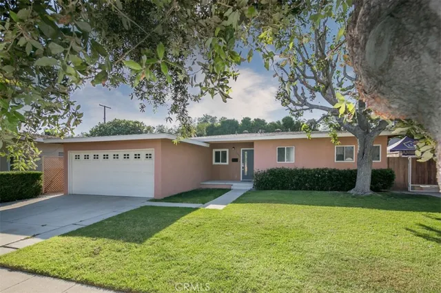 a view of a house with a yard and large tree