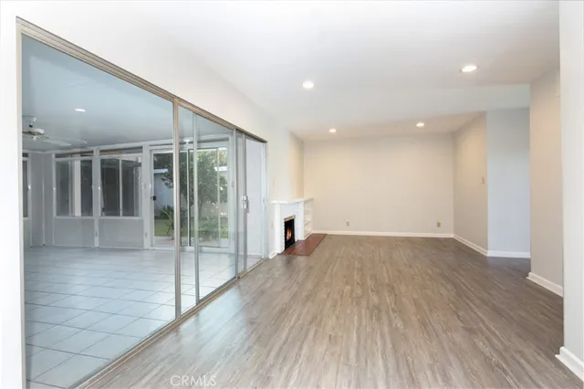 a view of a big room with wooden floor and windows