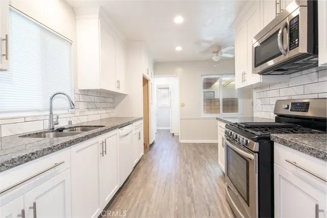 a kitchen with stainless steel appliances granite countertop a stove and a sink