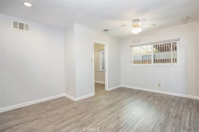a view of an empty room with wooden floor