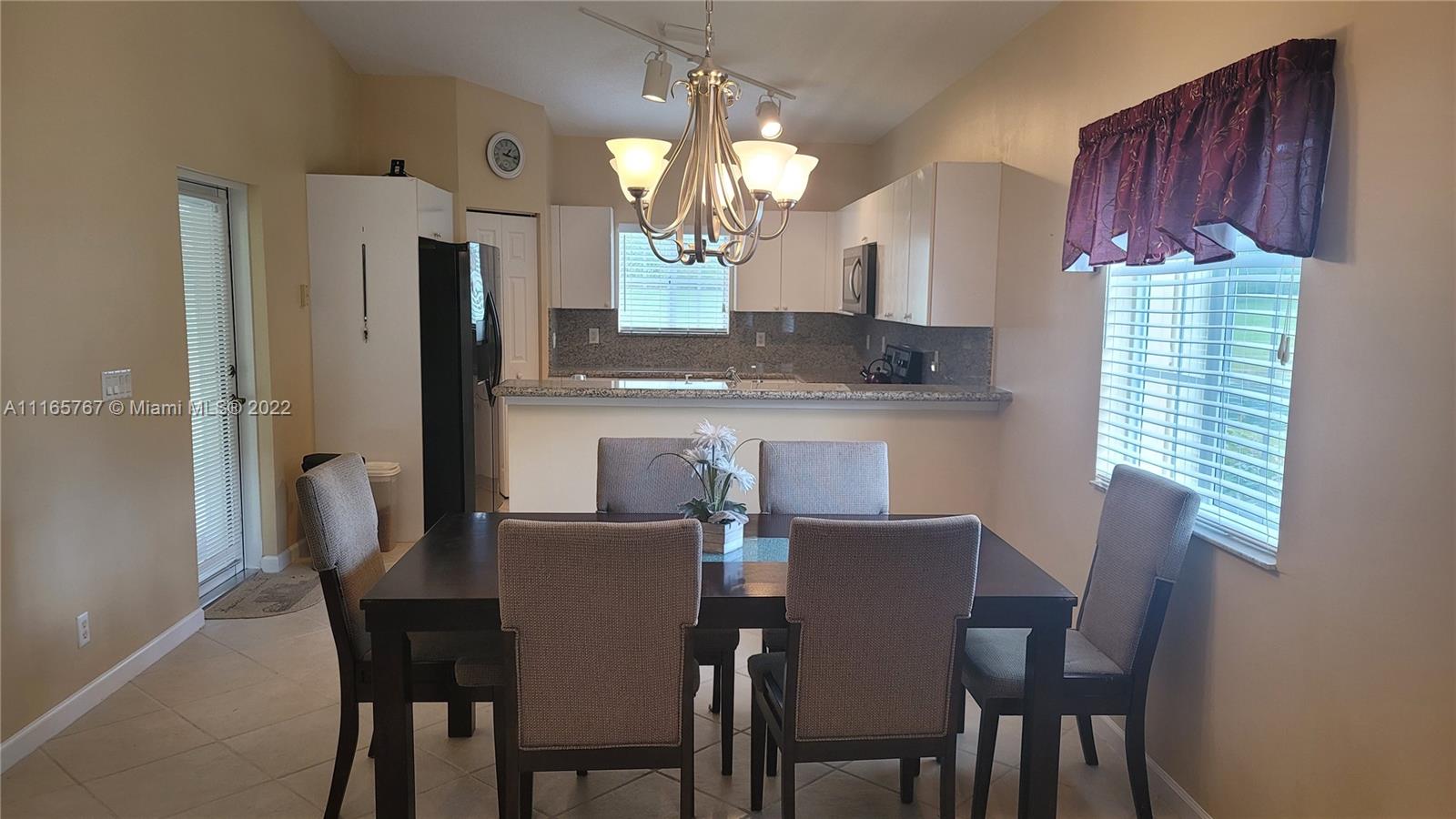 Baywinds West Palm Beach, FL 33411 - Photo 11 of 38 a view of a dining room with furniture and a chandelier