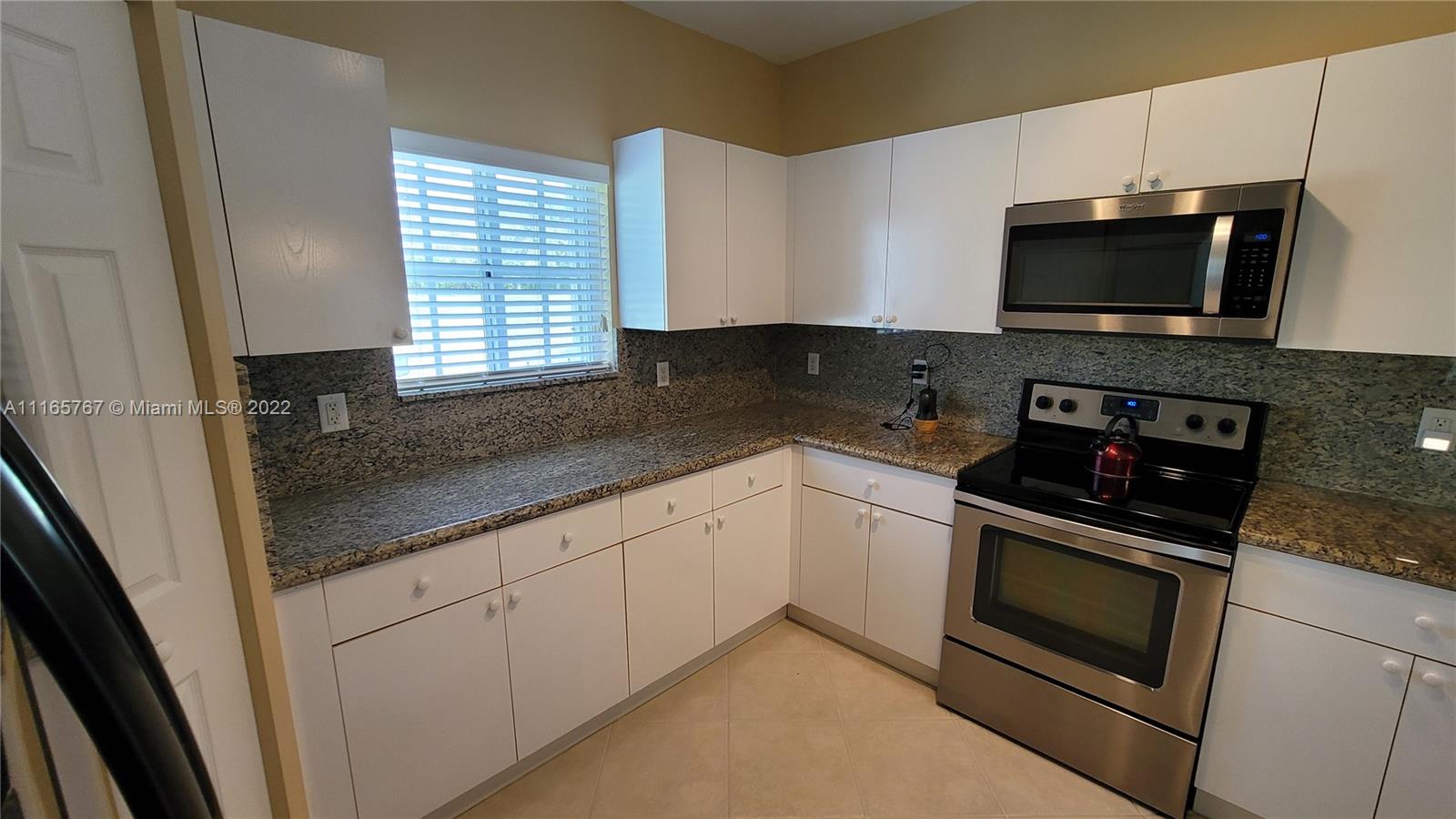 Baywinds West Palm Beach, FL 33411 - Photo 14 of 38 a kitchen with stainless steel appliances granite countertop a stove microwave and sink