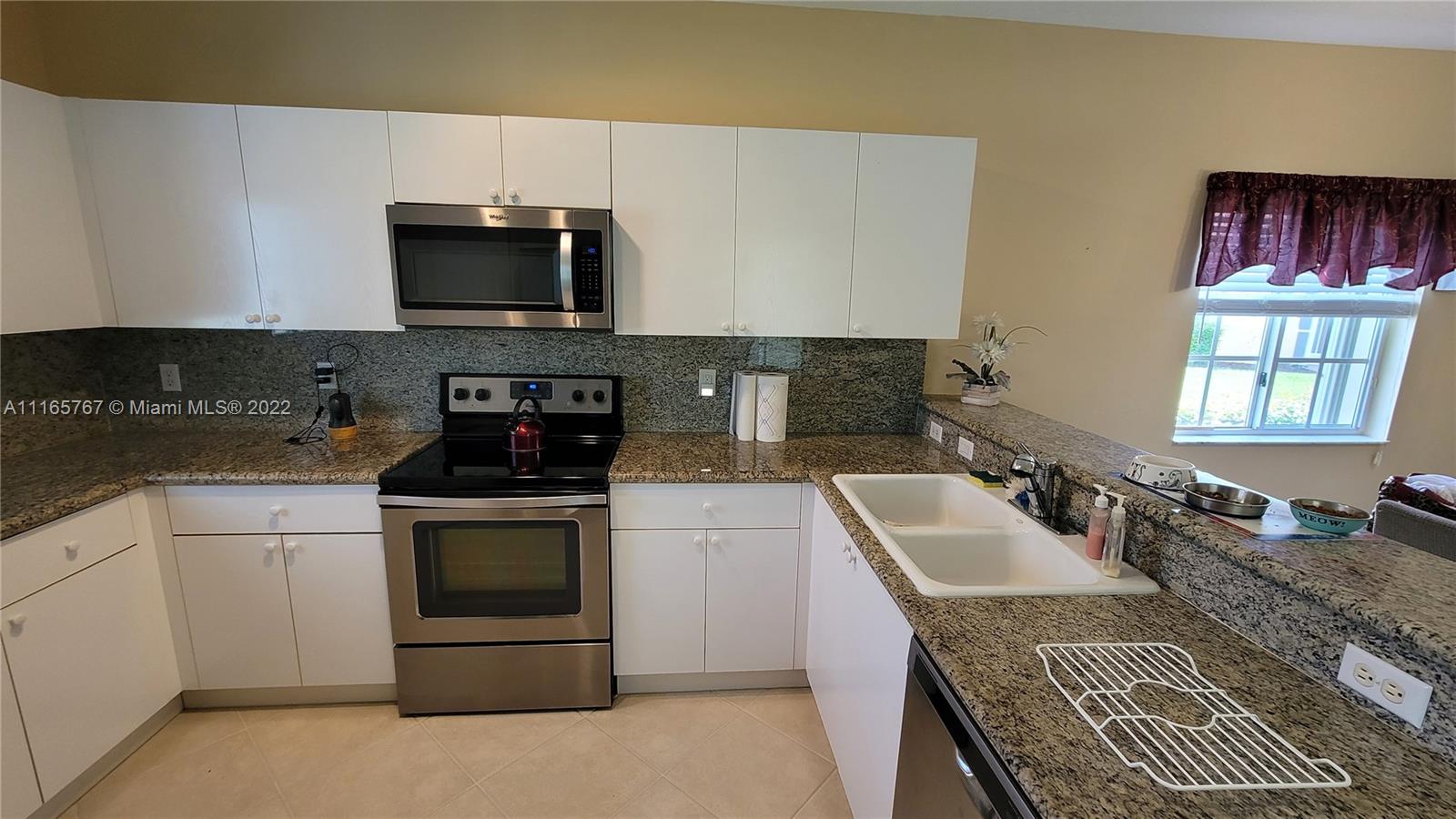 Baywinds West Palm Beach, FL 33411 - Photo 15 of 38 a kitchen with granite countertop stainless steel appliances a stove sink and microwave
