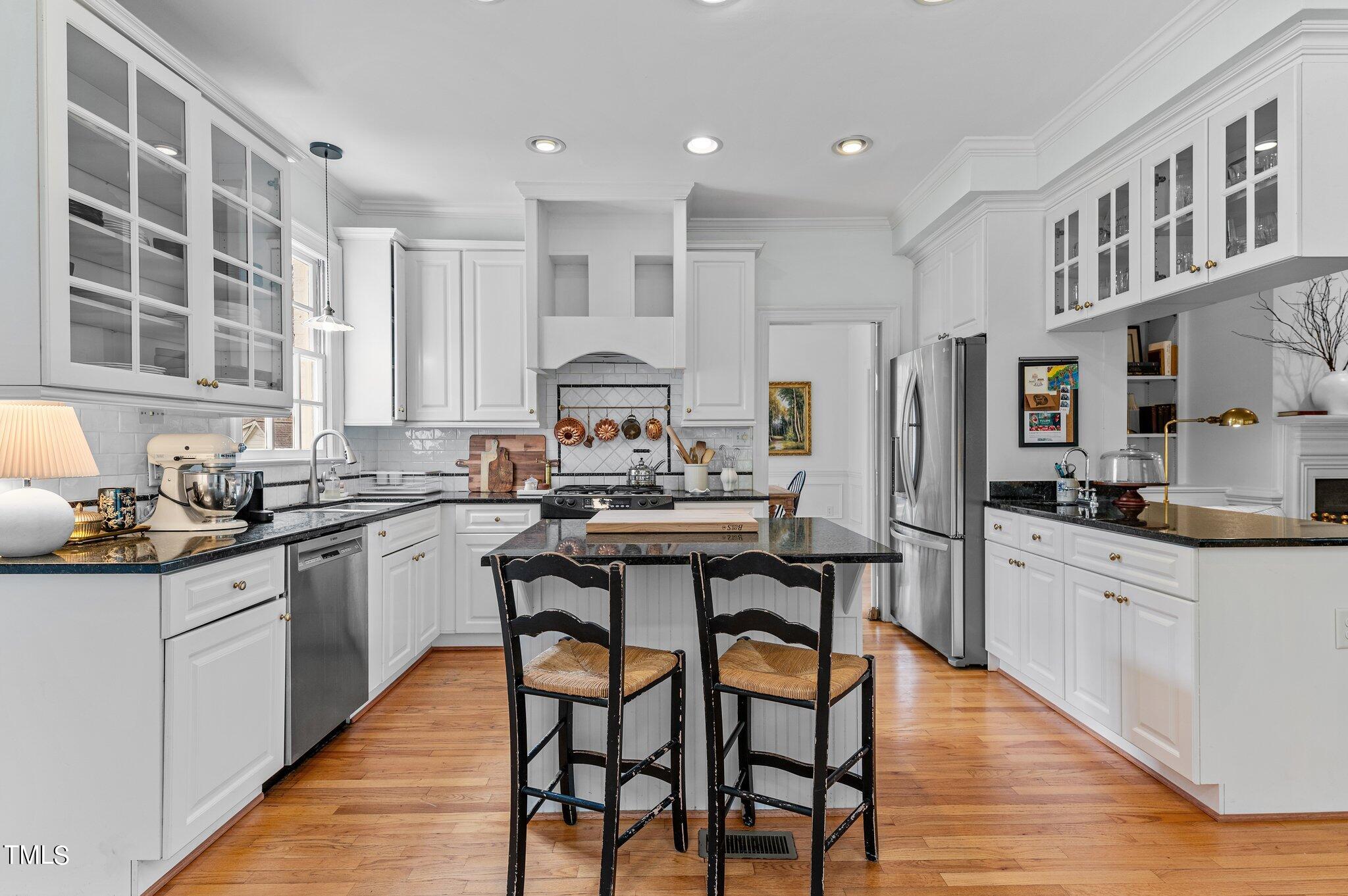 3000 Woodgreen Drive Raleigh, NC 27607 - Photo 13 of 55 a kitchen with stainless steel appliances granite countertop a table chairs stove a sink dishwasher and cabinets