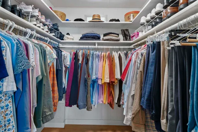 a view of walk in closet with clothes and shoes
