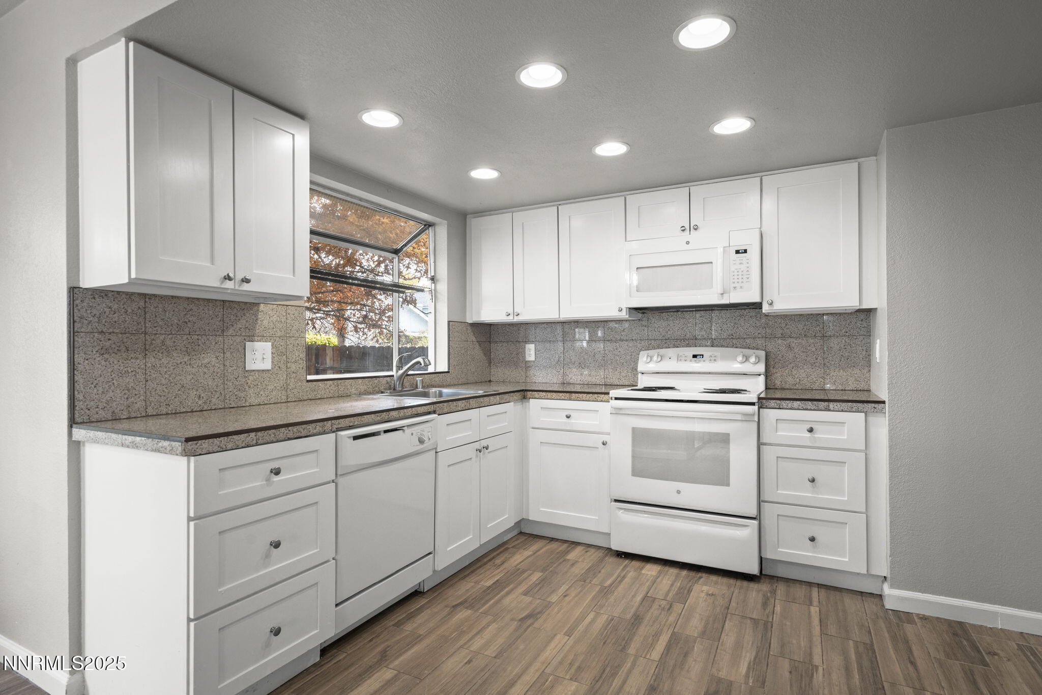2768 Azuza Way Reno, NV 89502 - Photo 12 of 26 a kitchen with granite countertop white cabinets and white appliances