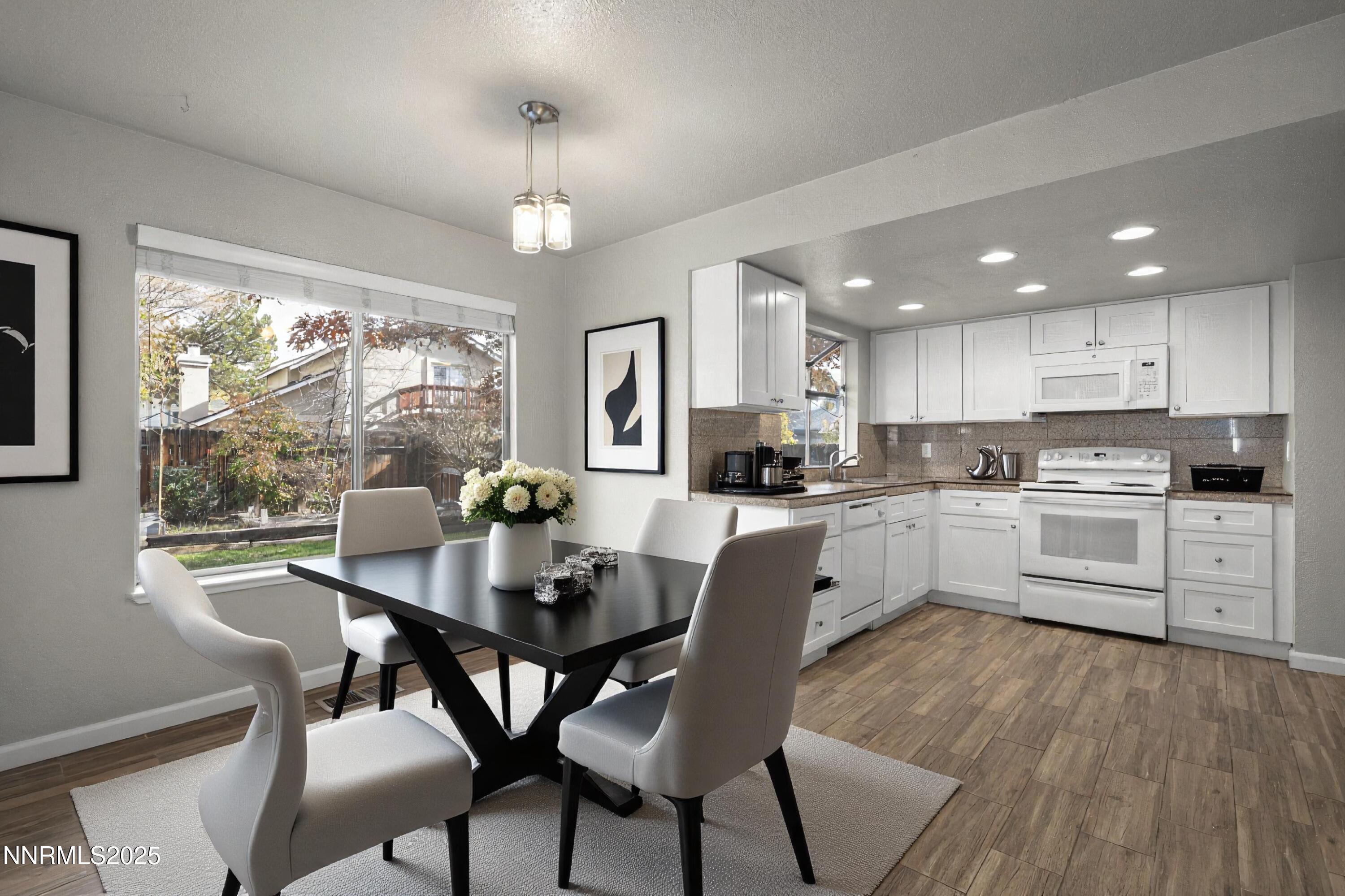 2768 Azuza Way Reno, NV 89502 - Photo 9 of 26 a kitchen with white cabinets stainless steel appliances dining table and chairs