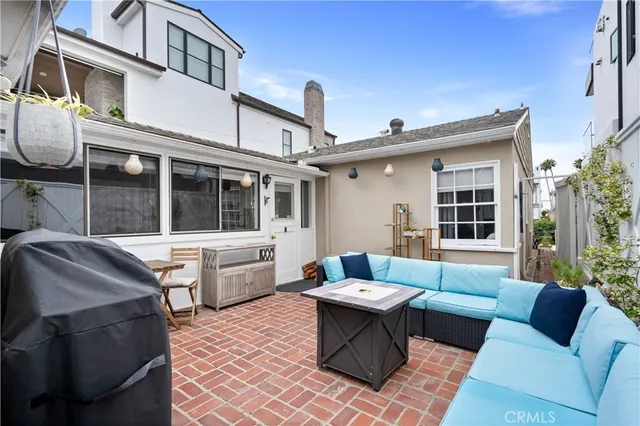 a view of a patio with couches table and chairs with wooden floor and fence