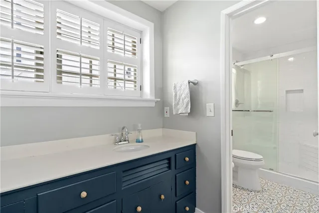 a bathroom with a sink a toilet a large mirror and shower