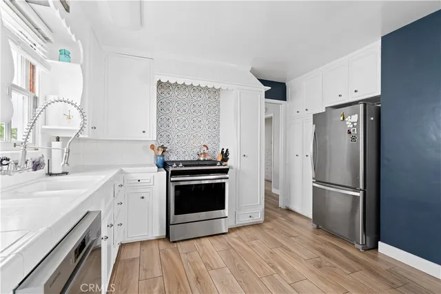 a kitchen with stainless steel appliances a stove a sink and a refrigerator