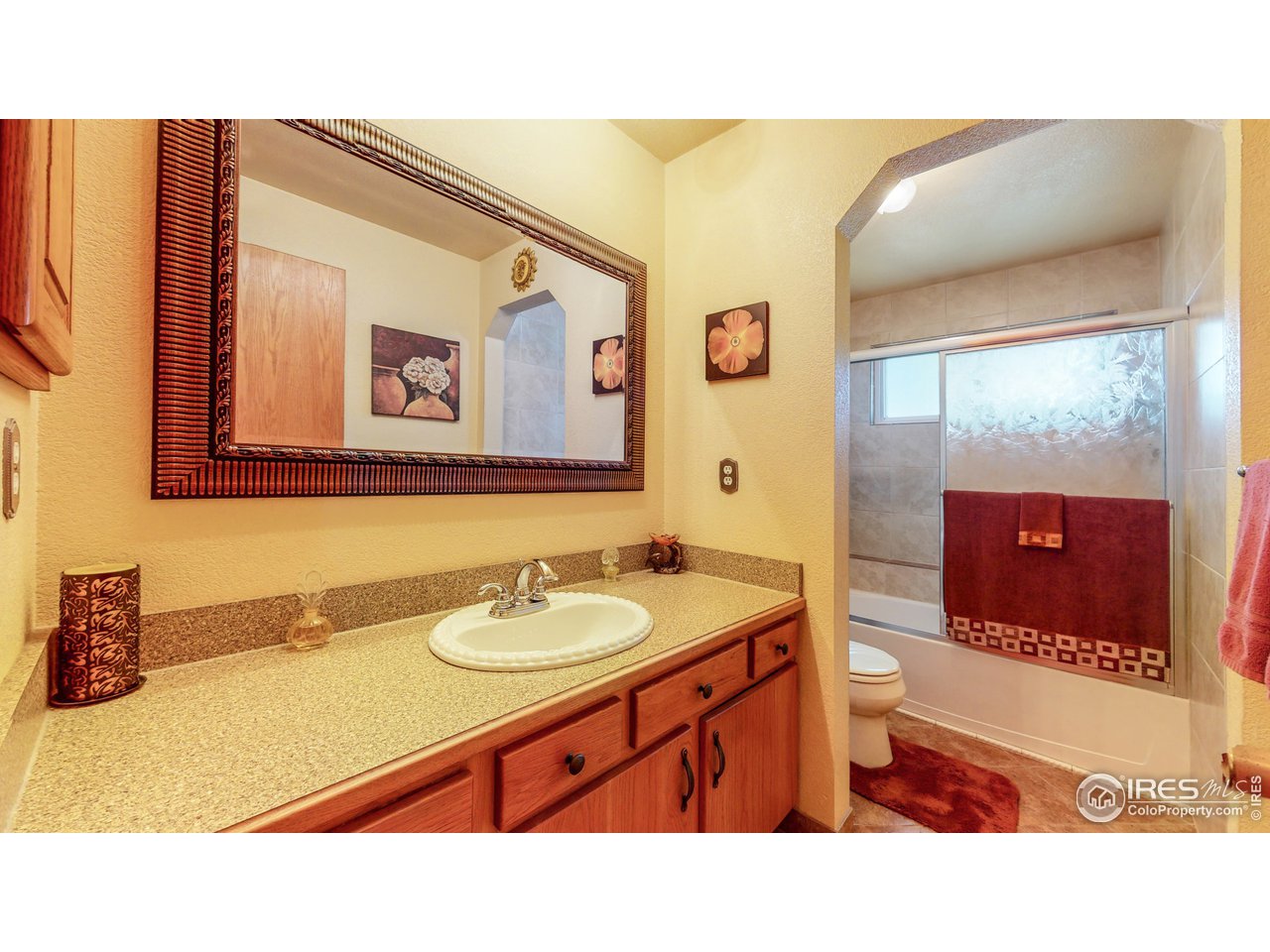 1554 Ervine Avenue Longmont, CO 80501 - Photo 16 of 31 a bathroom with a sink a mirror and a shower