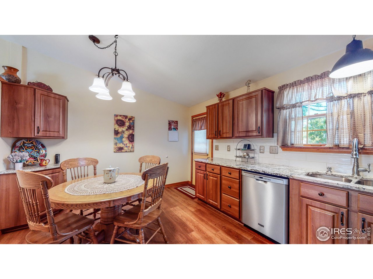 1554 Ervine Avenue Longmont, CO 80501 - Photo 7 of 31 a kitchen with a dining table chairs sink and cabinets